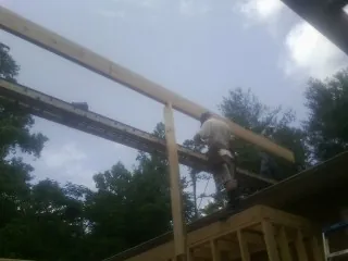 Carpenter setting a ridge beam over a new addition frame — Ice Dam Removal by Roofing Brothers in Nisswa
