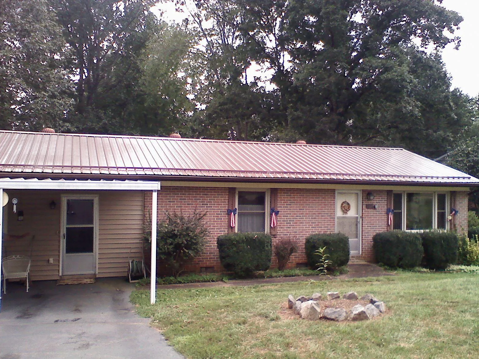 Bronze metal roof and carport on a brick ranch home — Roof Repair work by our crew in Nisswa